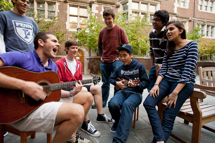 Students sit around a guitar player on the Junior Balcony