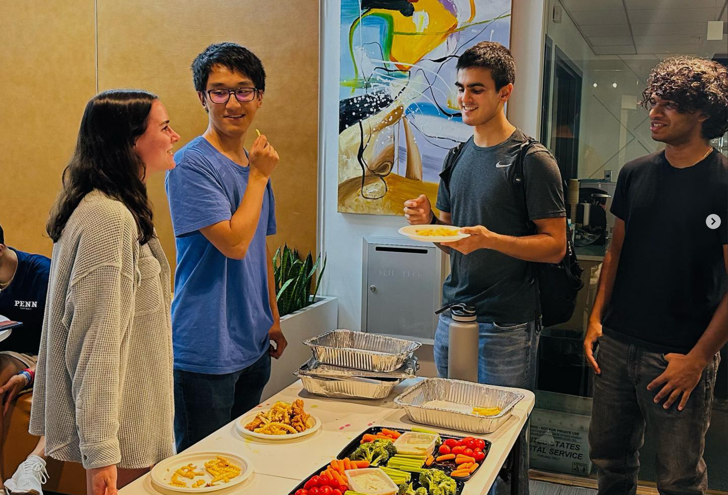 Radian residents meet up in a lobby while snacking on a vegetable tray