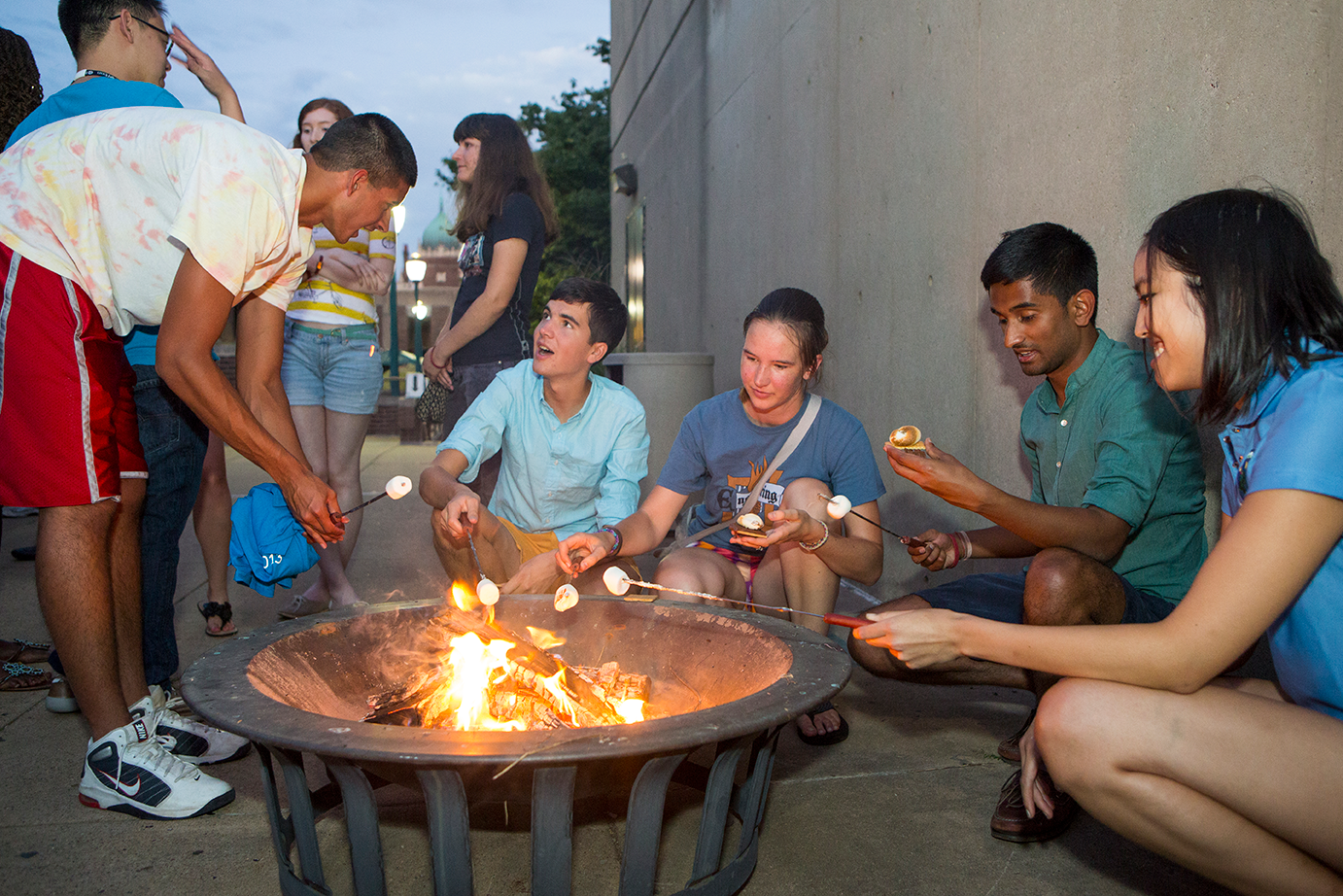 Stouffer residents roast marshmallows and converse around a firepit on the Stouffer patio